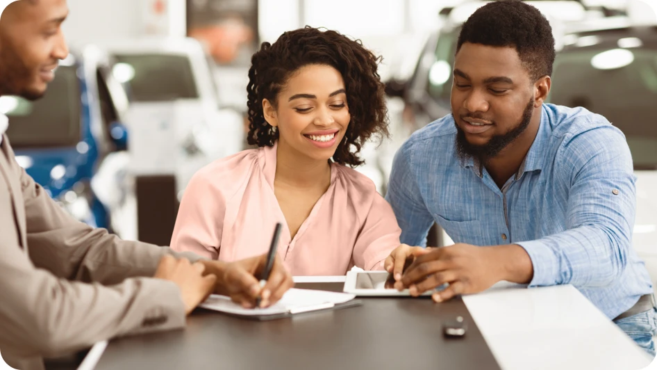 Buyers completing paperwork with the dealership